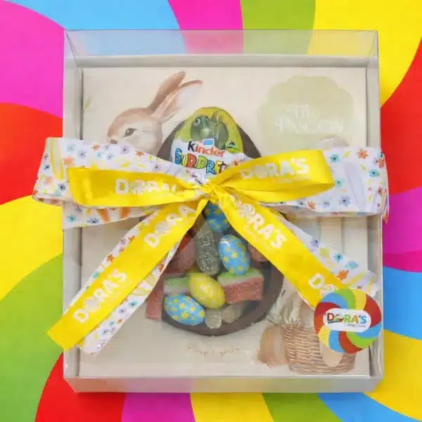 Meio ovo de chocolate com gomas dentro dele e um laço.