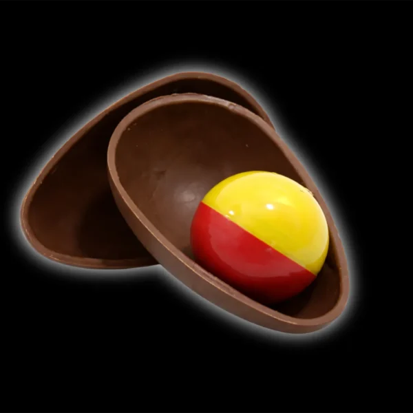 Imagem de ovo de chocolate partido com brinde dentro de uma metdade