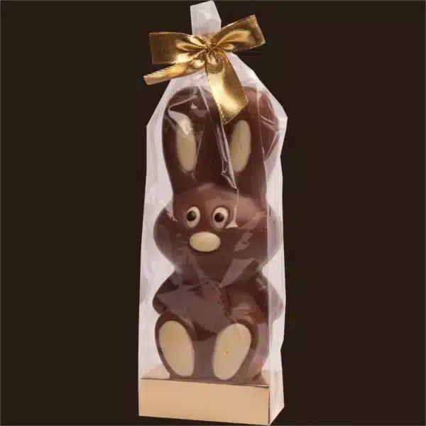 Coelho de chocolate embalado com laço dourado.